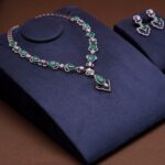 Elegant emerald necklace and earrings set on velvet background, perfect for showcasing luxury and style.